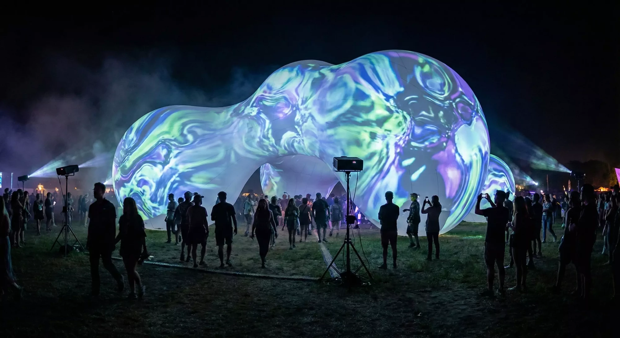 Inflatable sculpture covered in projection mapped animations at a festival.