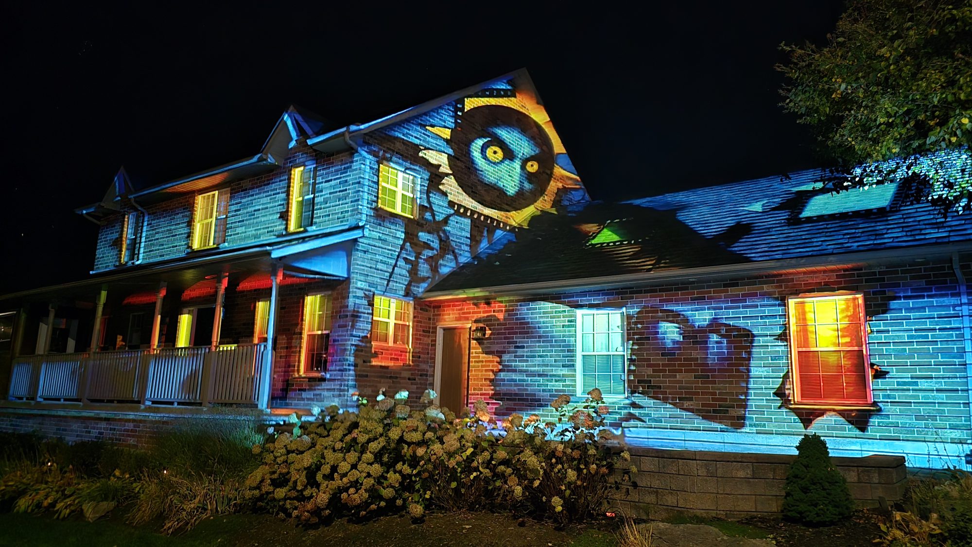 A Barrie home illuminated with a blue Halloween projection featuring a large owl