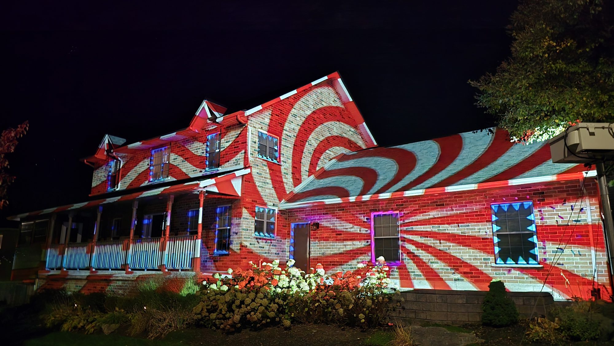 A Barrie home covered with a red and white Halloween projection pattern
